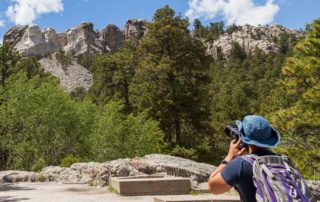 A man taking pictures of Mount Rushmore.