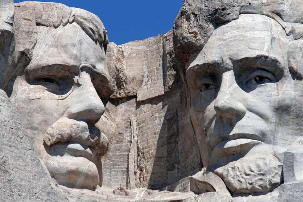 A close up photo of Mount Rushmore with book written about this monument.