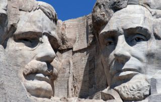 A close up photo of Mount Rushmore with book written about this monument.